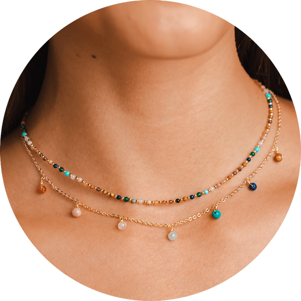 Necklace stack with a gold chain necklace with assortment of rainbow bead dewdrop charms and a 2mm assorted rainbow stone and gold bead necklace