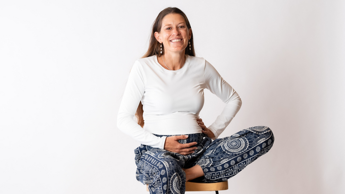 CEO of Lotus and Luna posing on a chair pregnant in harem pants