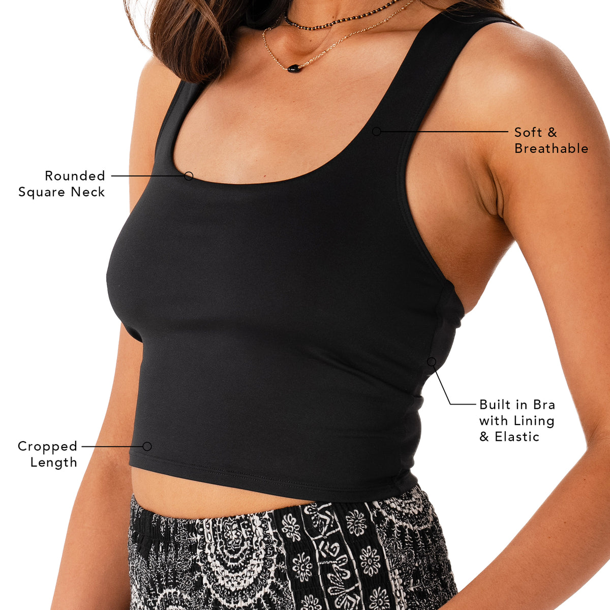 Model wearing a black athleisure tank top. Photo points out several features, including the cropped length, built in bra with lining and elastic, soft and breathable fabric and a rounded square neck
