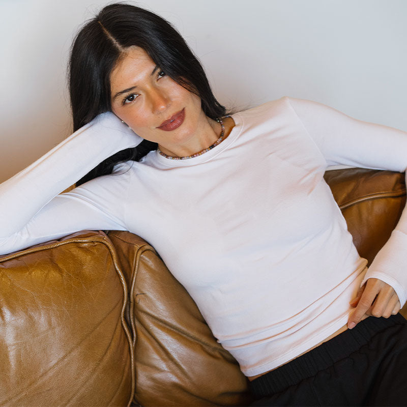 White Modal Halo Long Sleeve Top, reclining on sofa