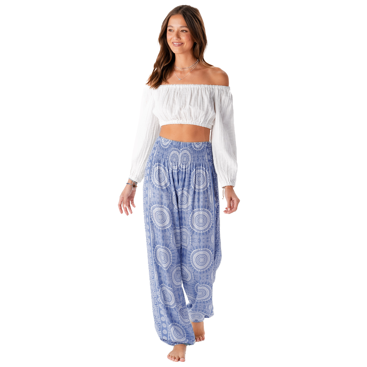 Model wearing an off shoulder white long sleeve top and a pair of periwinkle and white mandala print harem pants