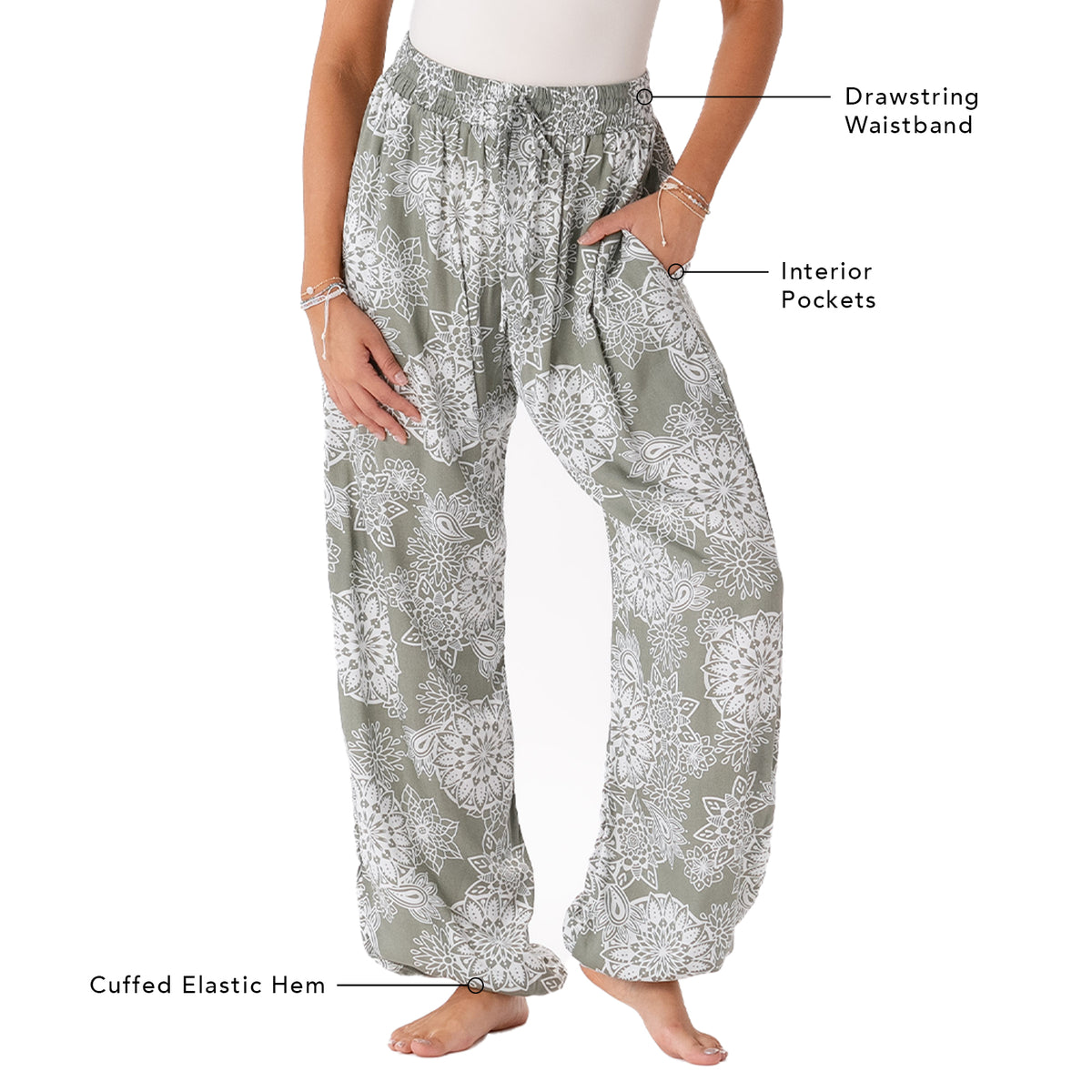 Model wearing fern colored harem pants with a mandala paisley print. Photo outlines the pant&#39;s features including drawstring waistband, interior pockets and a cuffed elastic bottom hem