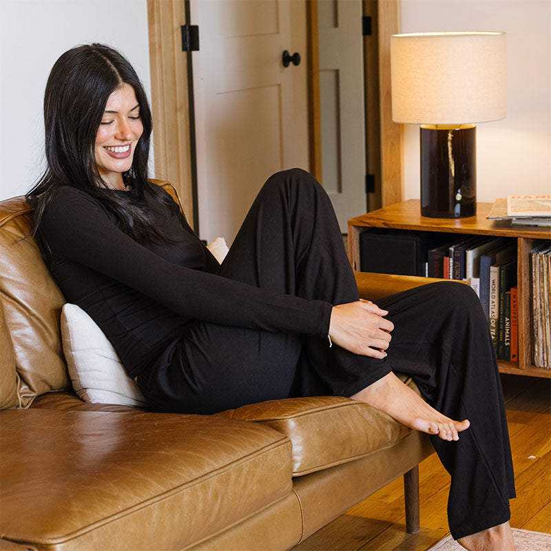 Black Modal Halo Long Sleeve Top and Sway Wide Leg Pants, seated with hand on knee