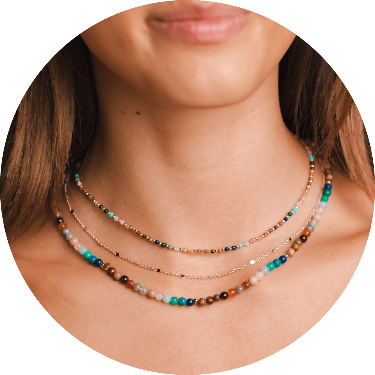 Model wearing a stack of healing necklaces. These necklaces include a 4mm multicolor stone healing necklace, a gold or silver chain necklace and a 2mm multicolored stone healing necklace.