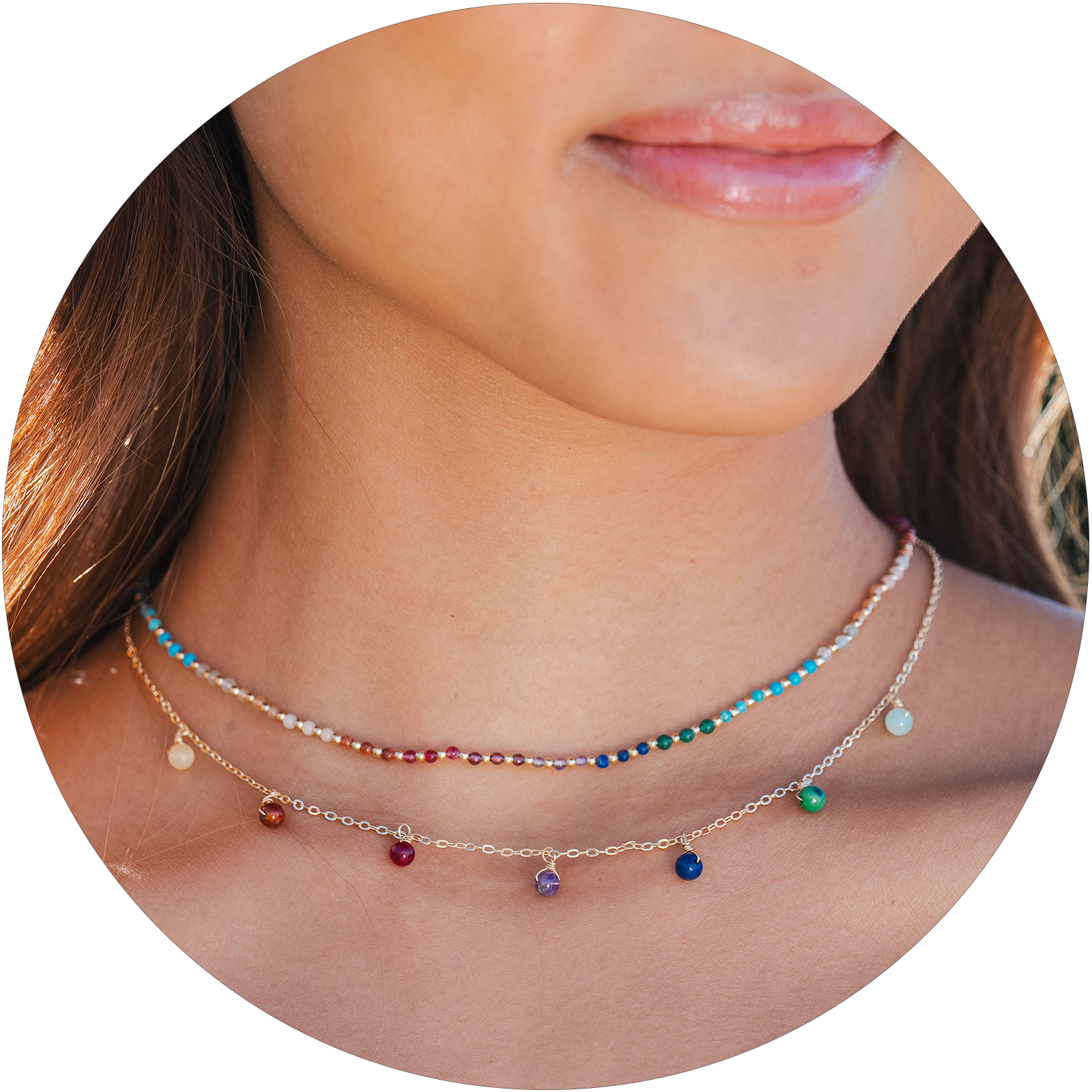 Model wearing a healing necklace stack. The necklaces include a 2mm multicolor stone and gold bead healing necklace and a multicolor stone dewdrop charm gold chain necklace